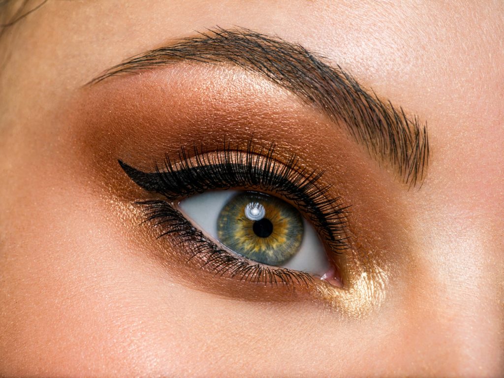 Beautiful female eye with brown, shiny makeup.